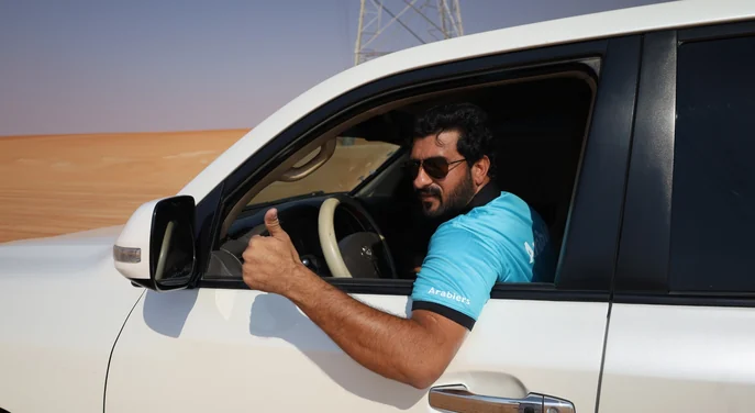 Arabiers Liwa desert guide giving a thumbs up from a Toyota Land Cruiser