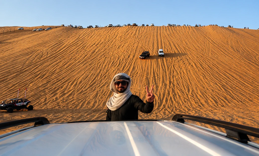 Visitor posing at the base of Tal Moreeb during the Liwa International Festival