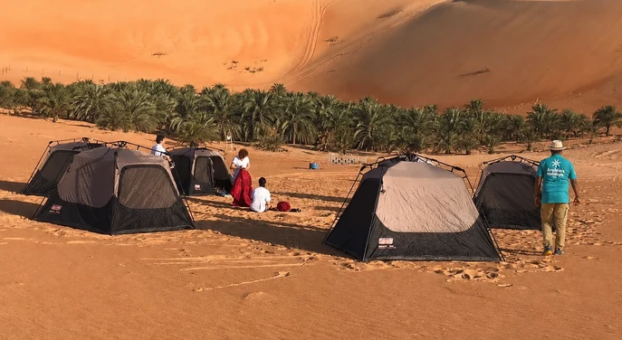 Overnight camping tents set beside the Liwa Oasis and towering Empty Quarter dunes