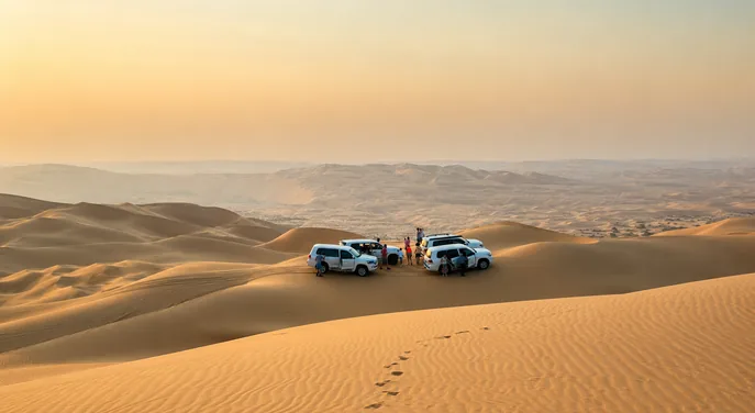 Private 4x4 vehicles paused among the Abu Dhabi desert dunes