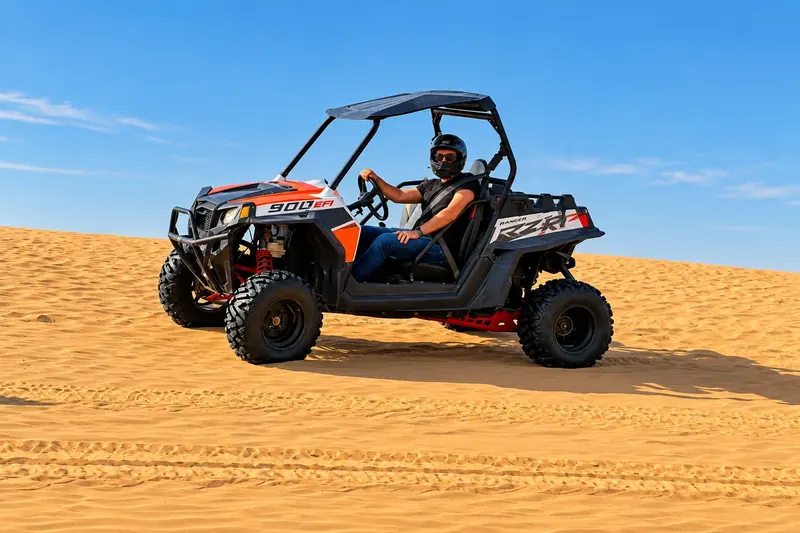 Driver seated in a Polaris RZR 900 dune buggy on the Abu Dhabi dunes