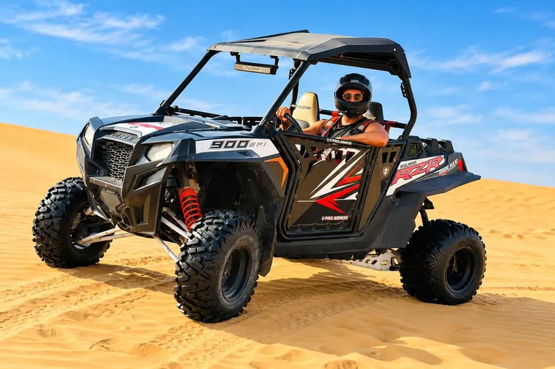 Driver in helmet and goggles in a Polaris RZR 900 dune buggy, Abu Dhabi desert