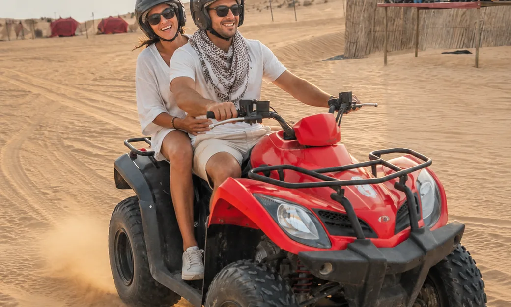 Guests riding a quad bike during a premium Abu Dhabi desert safari