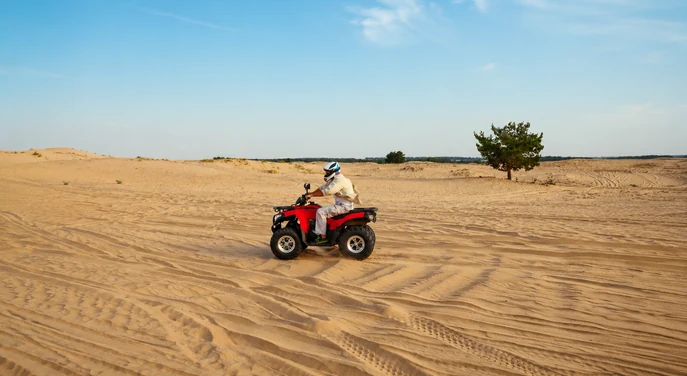 Solo rider driving a quad bike over Abu Dhabi desert sand
