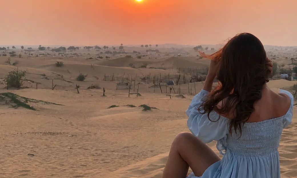Traveller photographing the sunrise over Abu Dhabi desert dunes