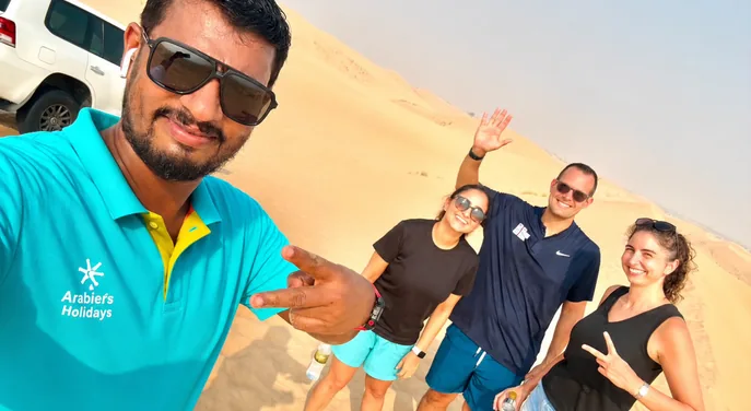 Arabiers guide taking a desert safari photo with guests