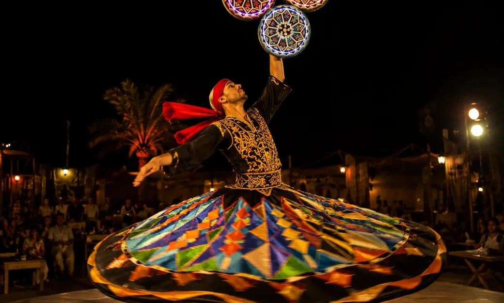 Tanoura dancer performing at an Abu Dhabi desert camp at night