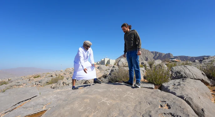 Local guide showing a traveller the rocky landscape near Jebel Harim in Khasab