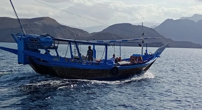 Guests relaxing aboard a traditional dhow cruising through the Musandam fjords