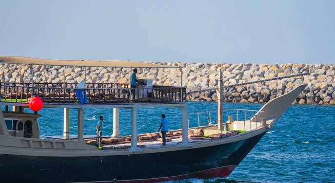 Open deck of a traditional dhow sailing on the blue waters of Musandam
