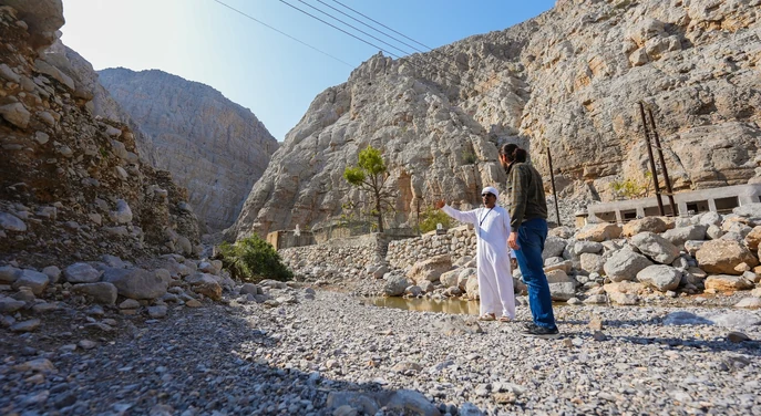 Local guide and traveller exploring the rocky mountain landscape of Musandam