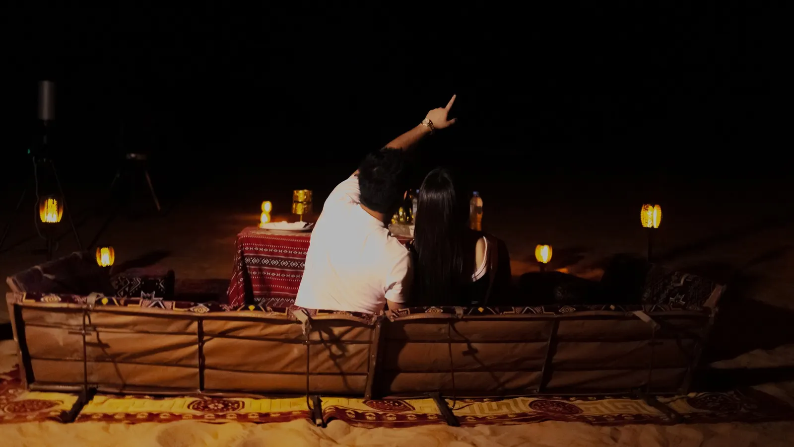 Couple looking up at the stars at a private desert dinner in Abu Dhabi