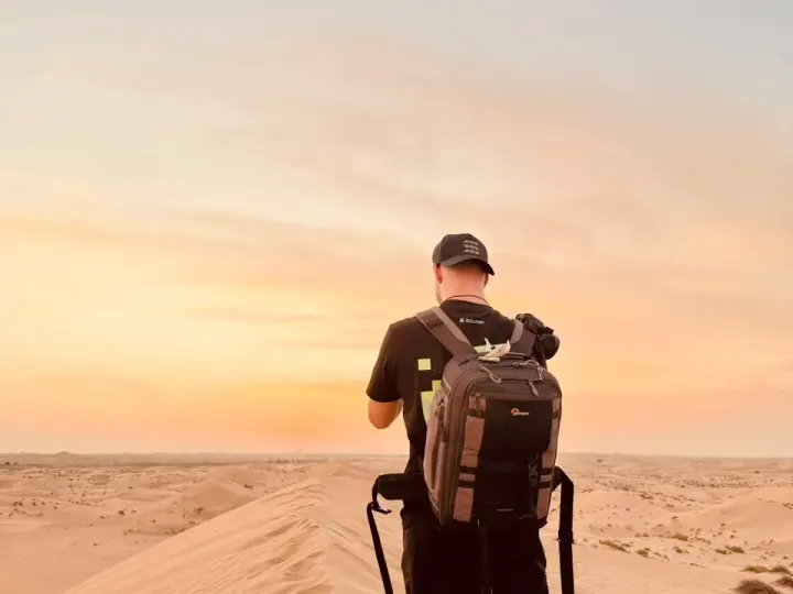 Guest on a dune ridge at golden hour on the private evening quad bike tour in Abu Dhabi