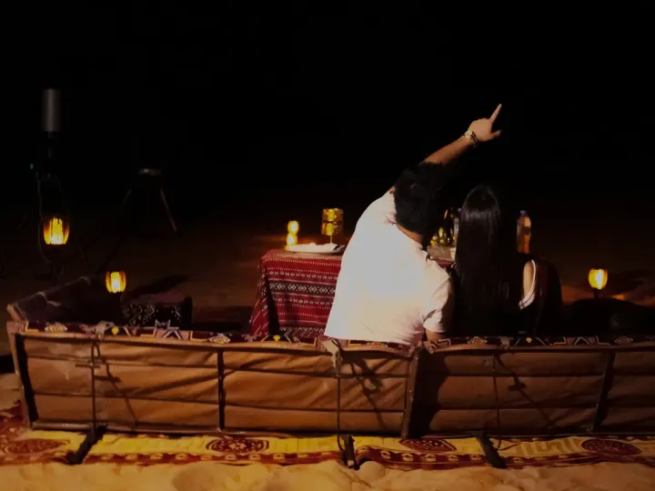 Couple stargazing at their private desert dinner after a quad bike ride in Abu Dhabi