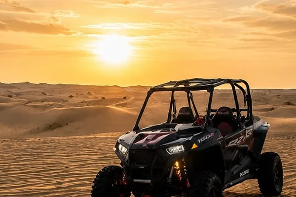 Polaris buggy parked on Abu Dhabi desert dunes at sunset