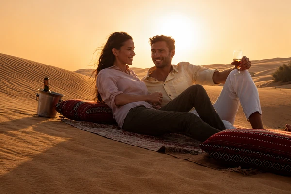Couple enjoying a romantic desert sunset picnic