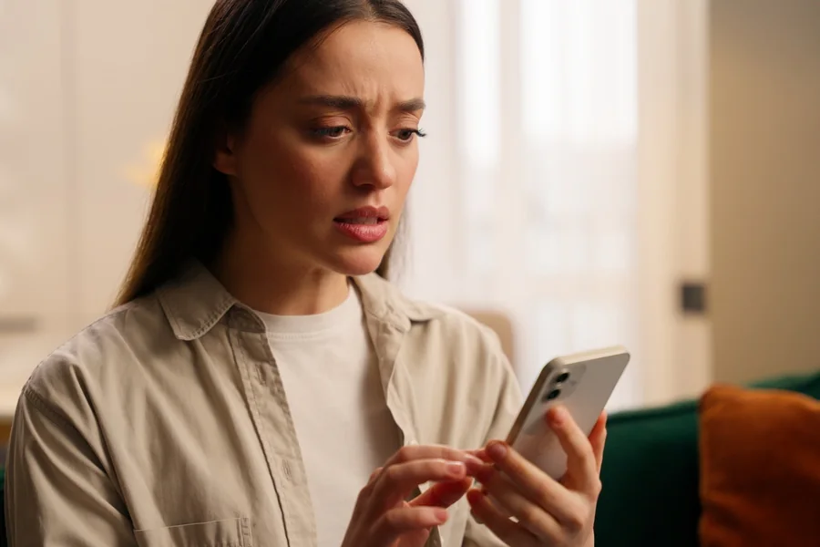 Woman at home checking UAE visa change status on a smartphone