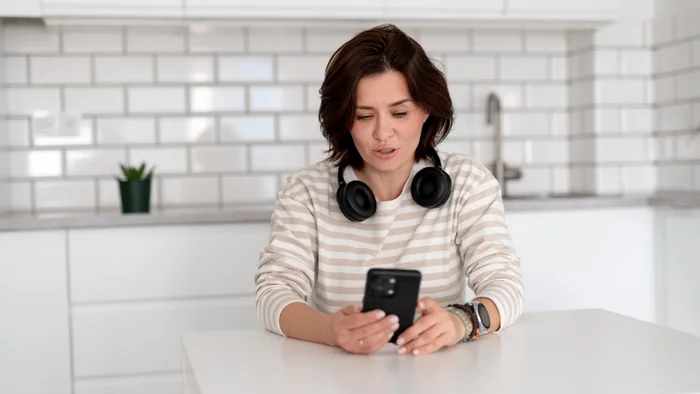 Applicant using a smartphone at home while checking Sharjah tourist visa requirements