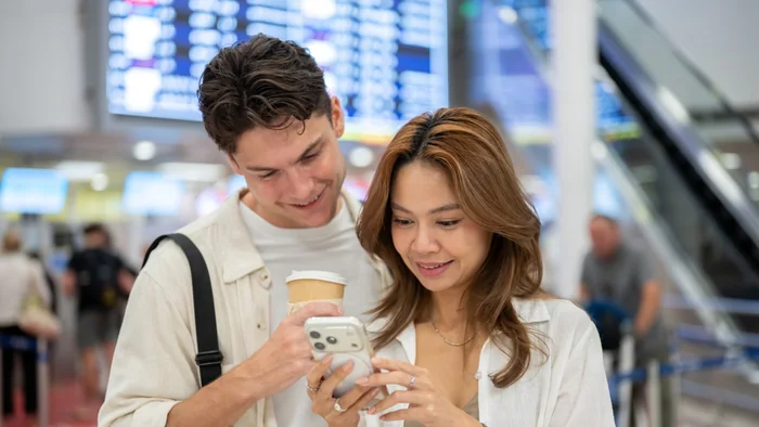Travellers checking documents at the airport before clearing a UAE overstay fine