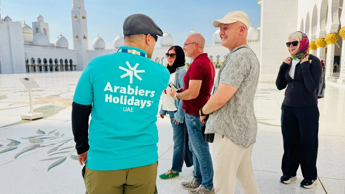 Arabiers guide explaining Sheikh Zayed Grand Mosque to visitors