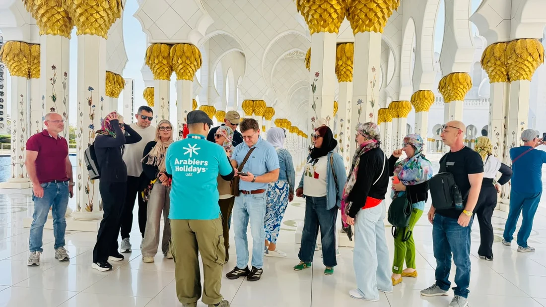 Emirati guide leading visitors at Sheikh Zayed Grand Mosque Abu Dhabi
