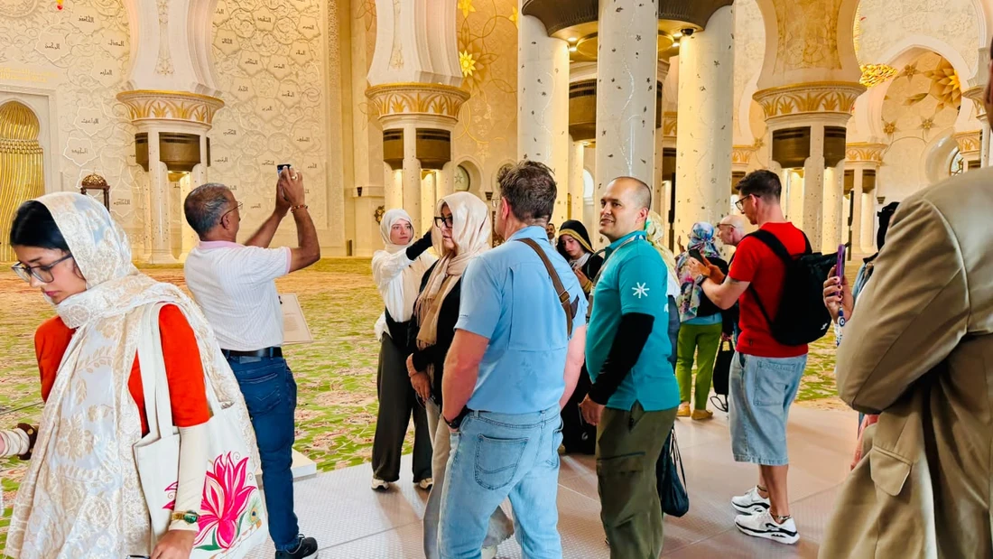 Visitors exploring the interior of Sheikh Zayed Grand Mosque on a guided visit